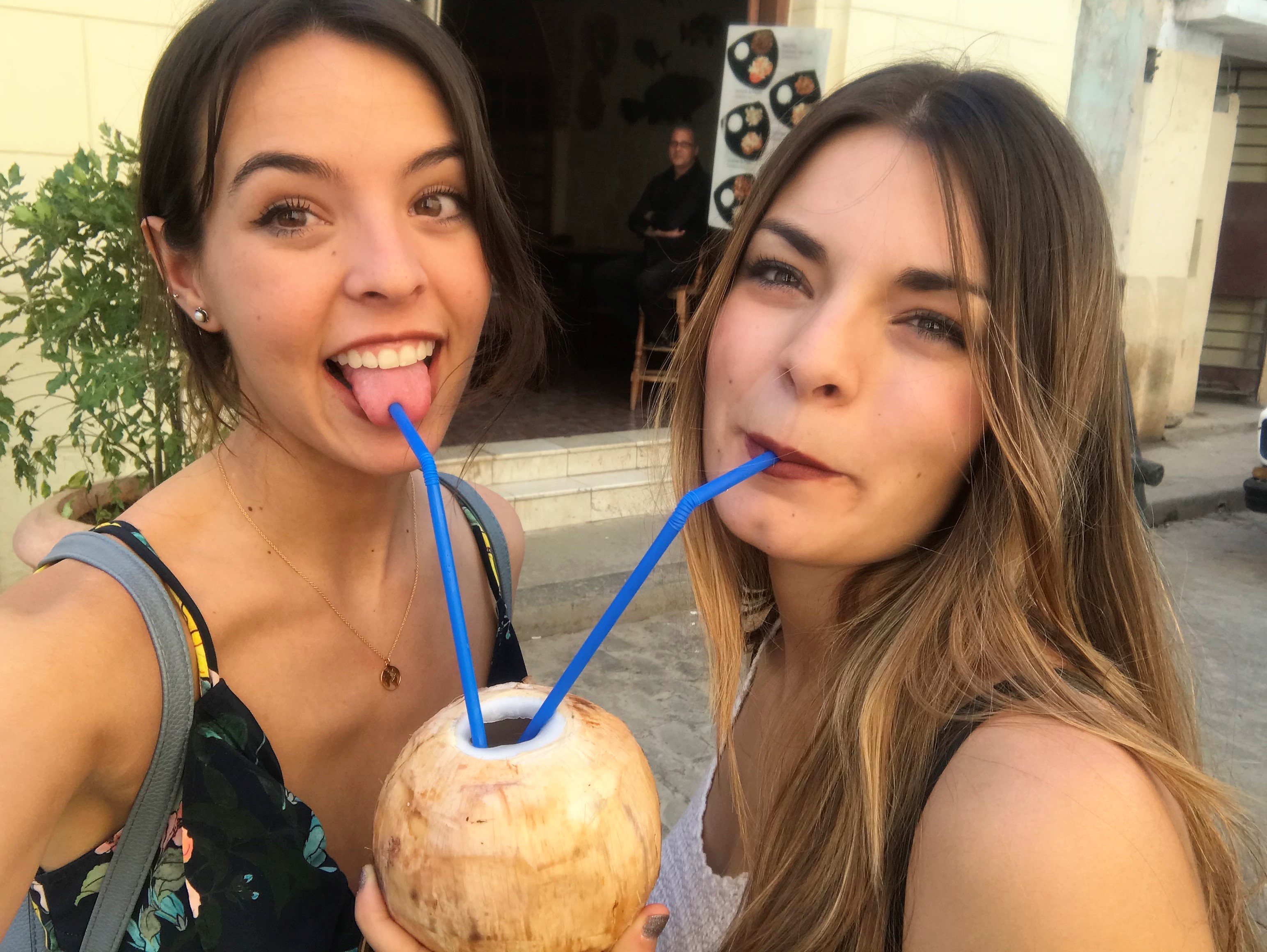 Marina y Lara probando un coco de un mercadillo de Habana